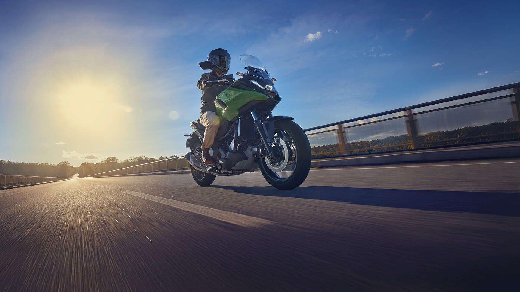 Modell, aki az NC750X motorkerékpáron halad az úton.